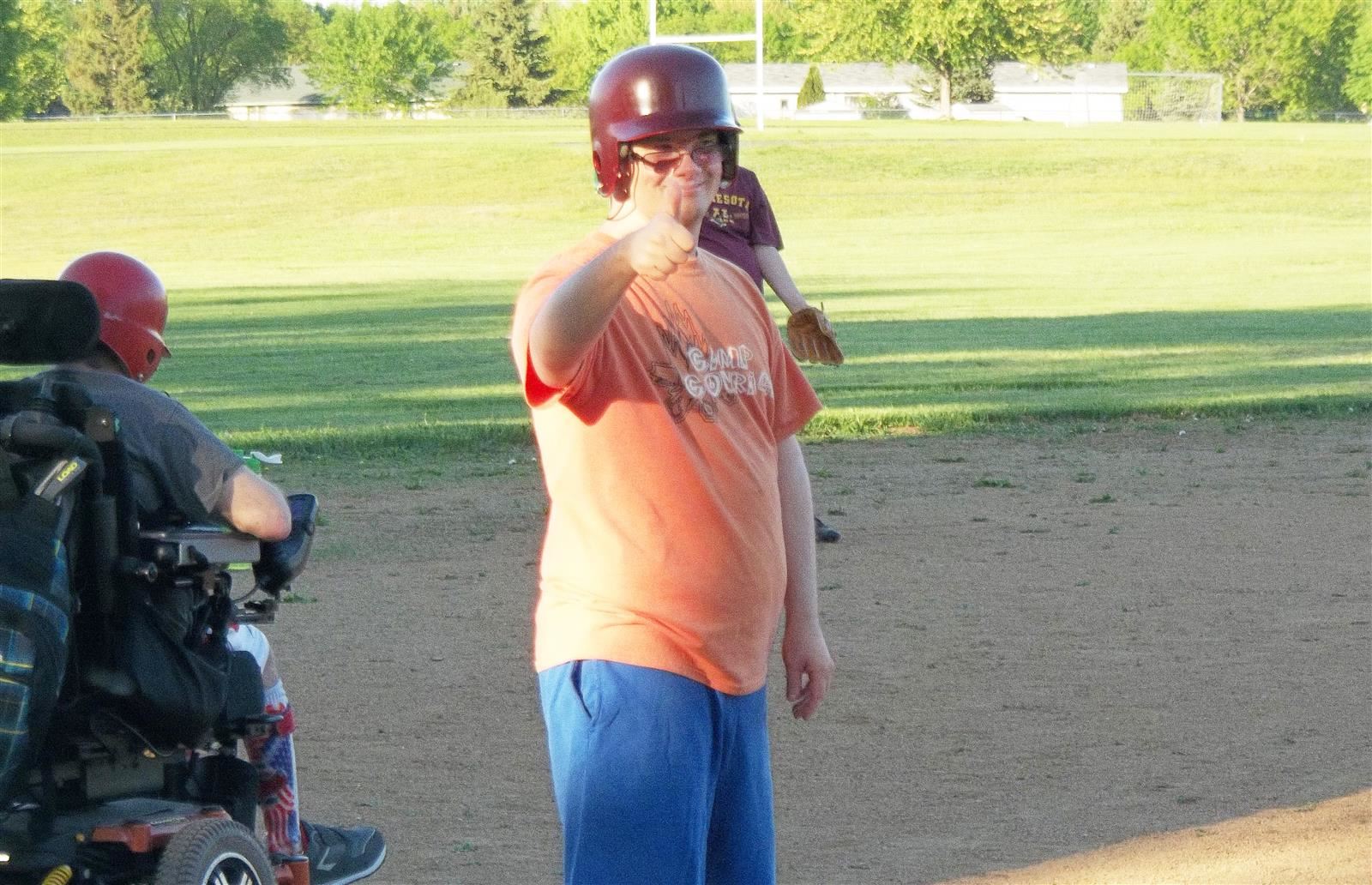 adults with disabilities play on softball field 